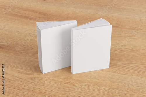 Two softcover or paperback vertical white mockup books standing on the wooden background. Blank front and back cover photo