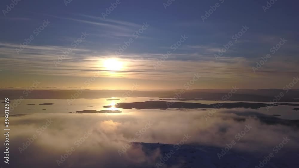 flying on a winter day in the sun among low clouds over the mountain and the white sea in the distance flying on a winter day in the sun among low clouds over the mountain and the white sea in the distance