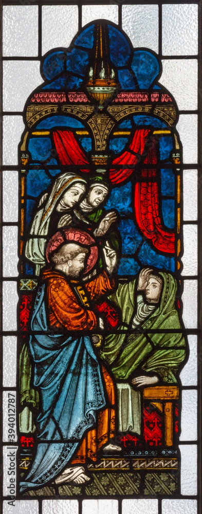 LONDON, GREAT BRITAIN - SEPTEMBER 19, 2017: The apostle Peter resurrects Tabitha on the stained glass in St Mary Abbot's church on Kensington High Street.