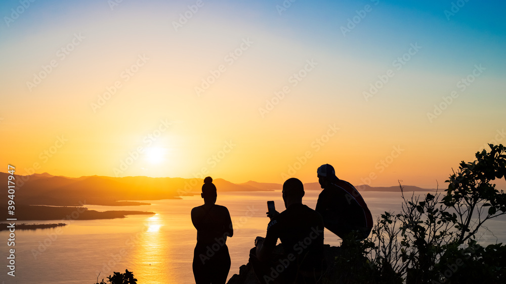 Groupe d'amis observant le lever de soleil sur la côte sud de la Martinique.