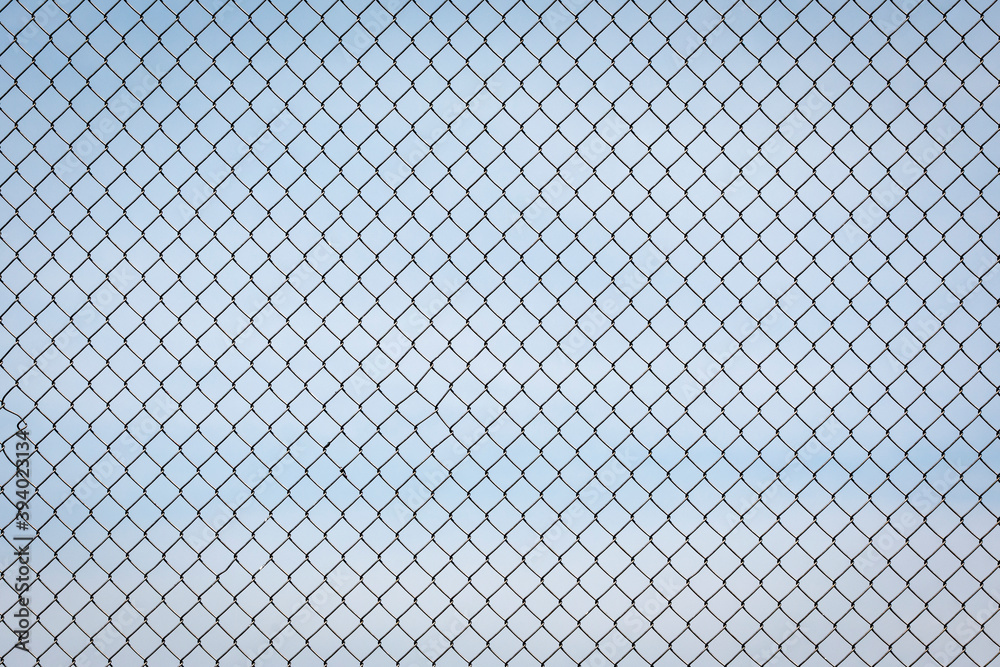 Fototapeta premium Chain Link Fence against a Cloudy Blue Sky