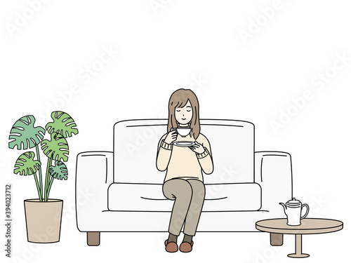 ソファーに座ってお茶を飲む女性　リラックス
