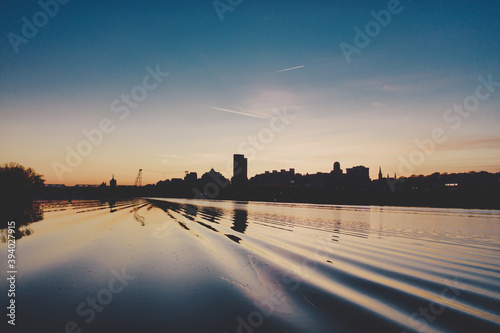 Albany NY Skyline at dusk seen from the Hudson River over the wake of a passing boat