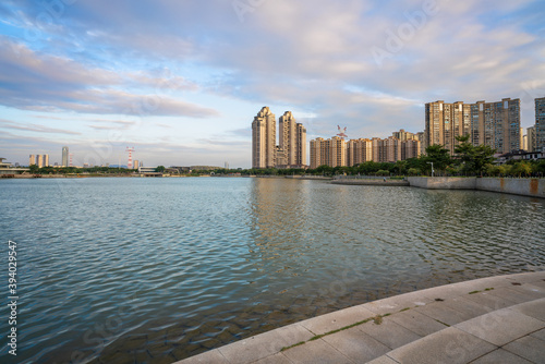 Modern skyline of residential buildings in Haicang District, Xiamen city, with lake foreground during the sunset photo