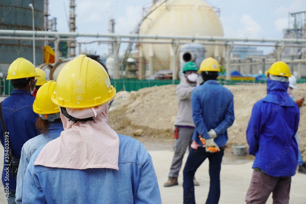 (Focus on the safety helmet) Construction worker in a safety meeting on morning talk before work at oil & Gas factory or Chemical plant under construction site. (Focus on the safety helmet) Construction worker in a safety meeting on morning talk before work at oil & Gas factory or Chemical plant under construction site.