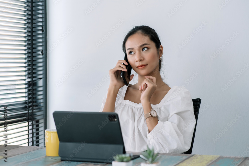 Attractive and successful asian businesswoman working in modern office, talking on phone with client at their desk. Attractive and successful asian businesswoman working in modern office, talking on phone with client at their desk.