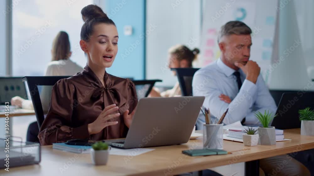 Businesswoman having video interview on laptop. Female professional waving hand Businesswoman having video interview on laptop. Female professional waving hand
