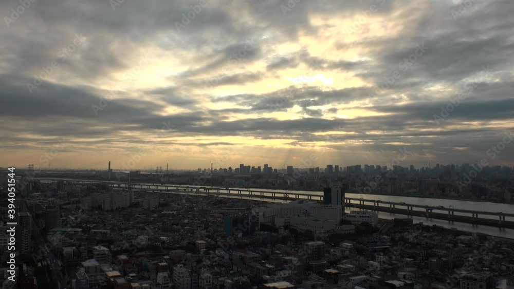TOKYO, JAPAN : Aerial high angle sunset or sunrise CITYSCAPE of TOKYO. View of central downtown area and River Arakawa. Japanese metropolis concept. Dramatic sky and clouds. Time lapse zoom out shot.