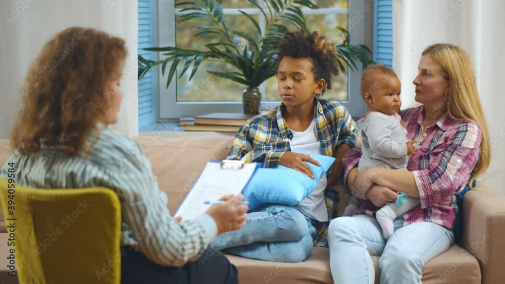 Female case worker visiting woman with adopted children