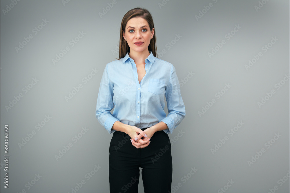 Woman in blue shirt standing with folded hands. Woman in blue shirt standing with folded hands.