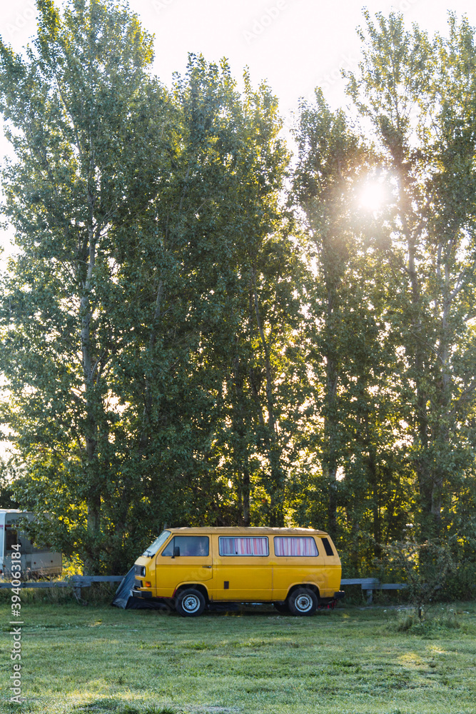 Obraz premium Yellow camper van at a campsite