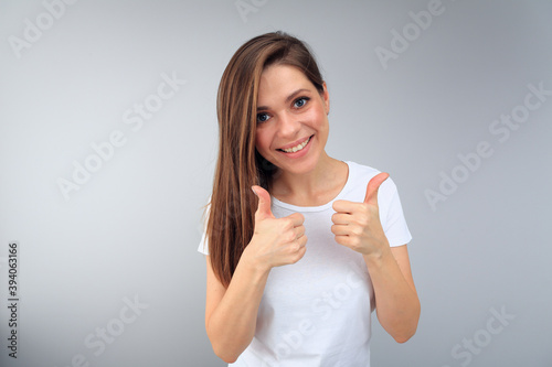 Happy smiling woman wearing white t shirt with copy space shows thumbs up.