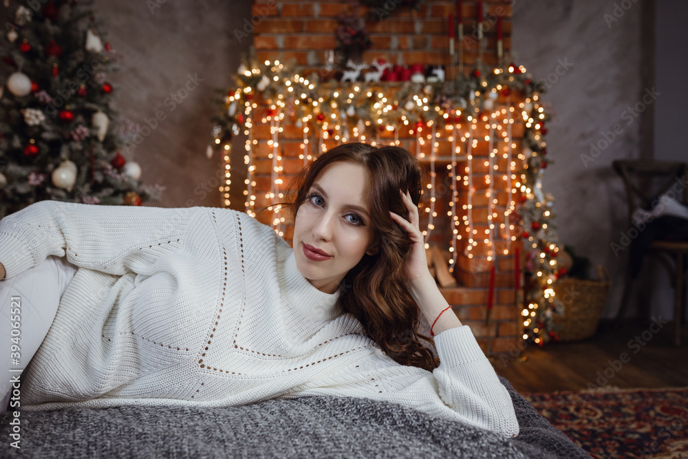 Beautiful model woman with perfect body in a cozy sweater sits on the bed Beautiful model woman with perfect body in a cozy sweater sits on the bed