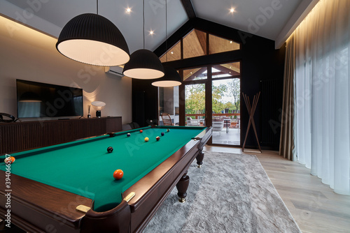 Photography modern billiard room with a beautiful table and large windows