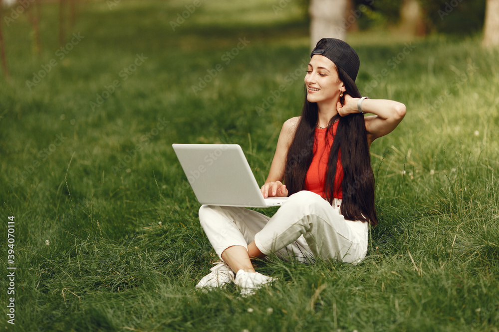 Woman in a spring city. Lady with a laptop. Girl sitting on a grass. Woman in a spring city. Lady with a laptop. Girl sitting on a grass.