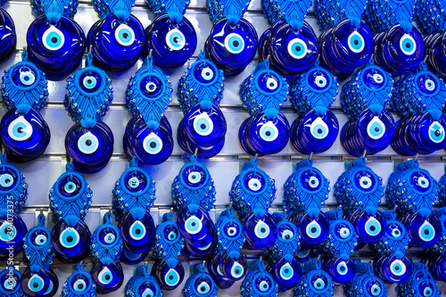 Various blue amulets evil eye beads nazar boncugu Hanging on the white colored wall background in antalya turkey
