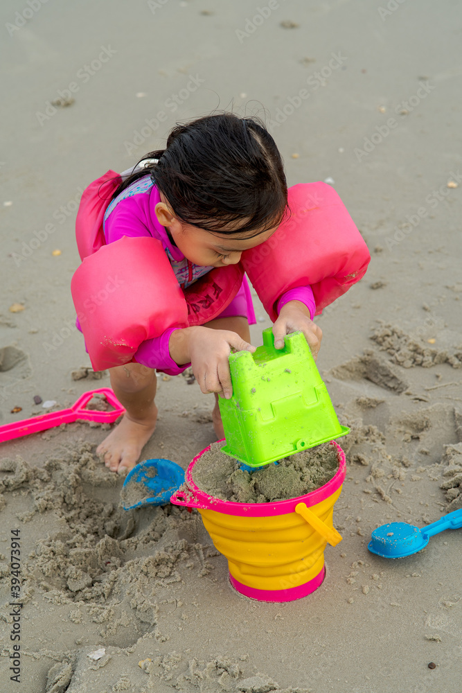 Portrait of little toddler girl playing sand at the beach. Portrait of little toddler girl playing sand at the beach.