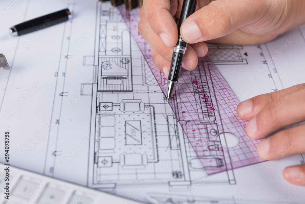 Hand over construction plans with yellow helmet. laptop and drawing tool Hand over construction plans with yellow helmet. laptop and drawing tool