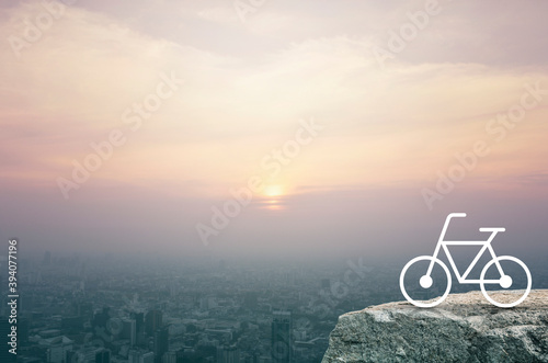 Bicycle flat icon on rock mountain over aerial view of cityscape at sunset, vintage style, Business healthy lifestyle concept