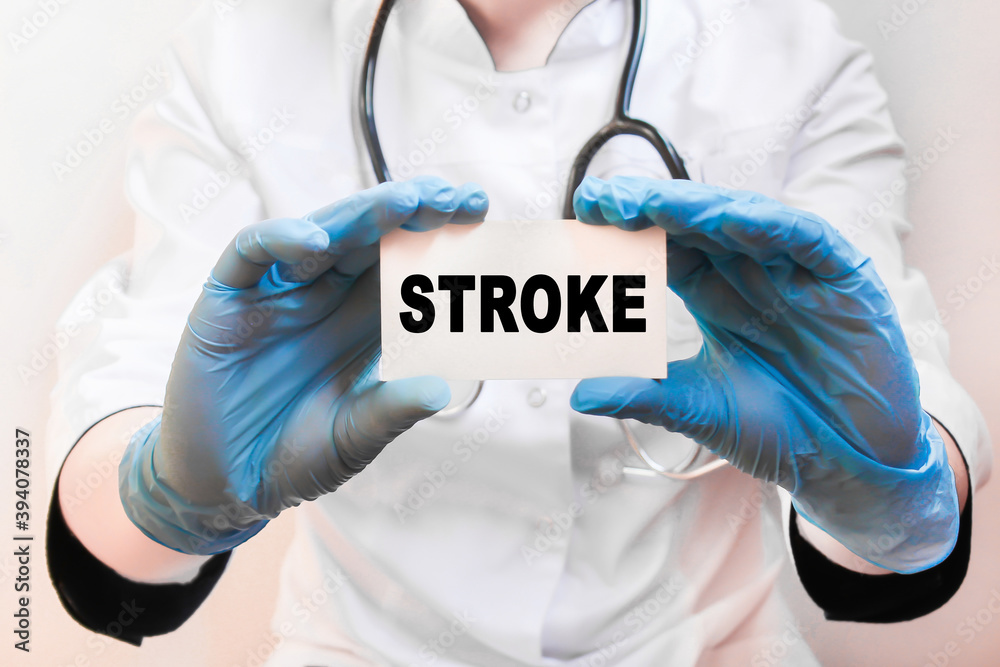The doctor's blue - gloved hands show the word STROKE - . a gloved hand on a white background. Medical concept. the medicine The doctor's blue - gloved hands show the word STROKE - . a gloved hand on a white background. Medical concept. the medicine