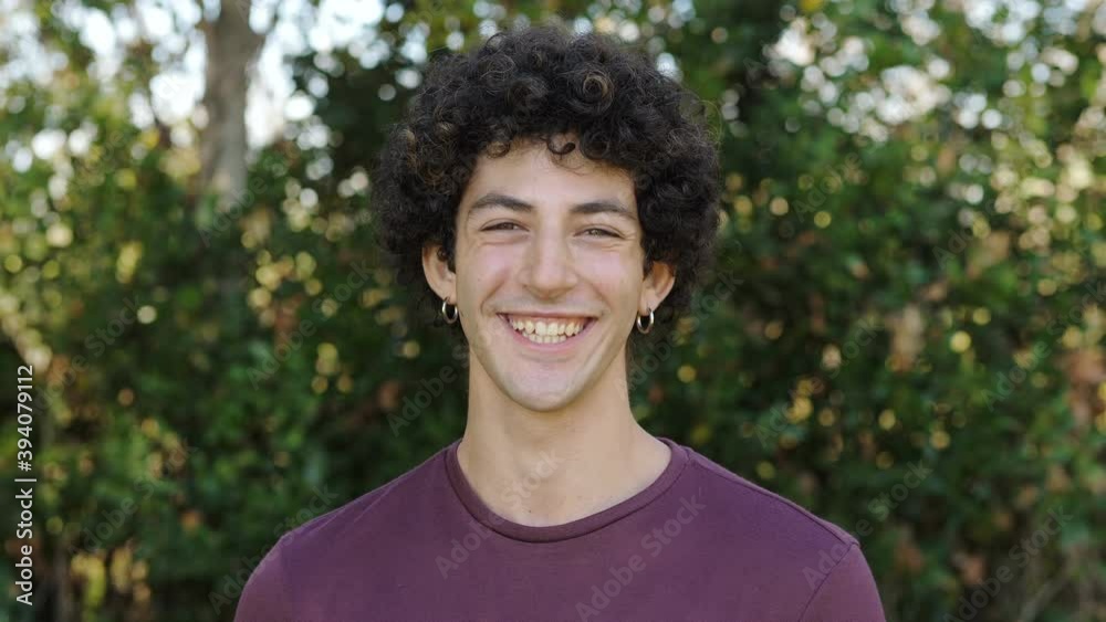 joy, lightheartedness -young serious man changes expression and smiles at camera joy, lightheartedness -young serious man changes expression and smiles at camera