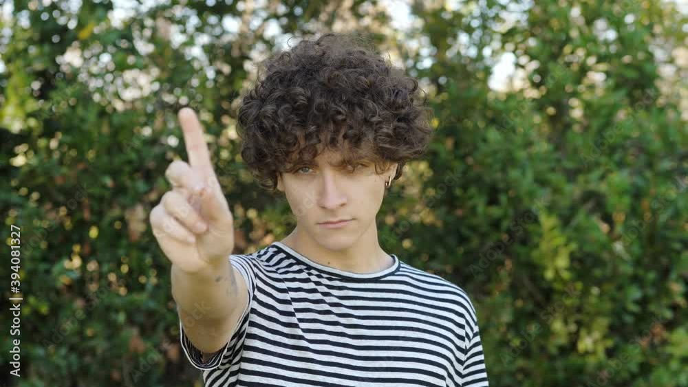negation, forbid - young serious man makes no to the camera - outdoor negation, forbid - young serious man makes no to the camera - outdoor