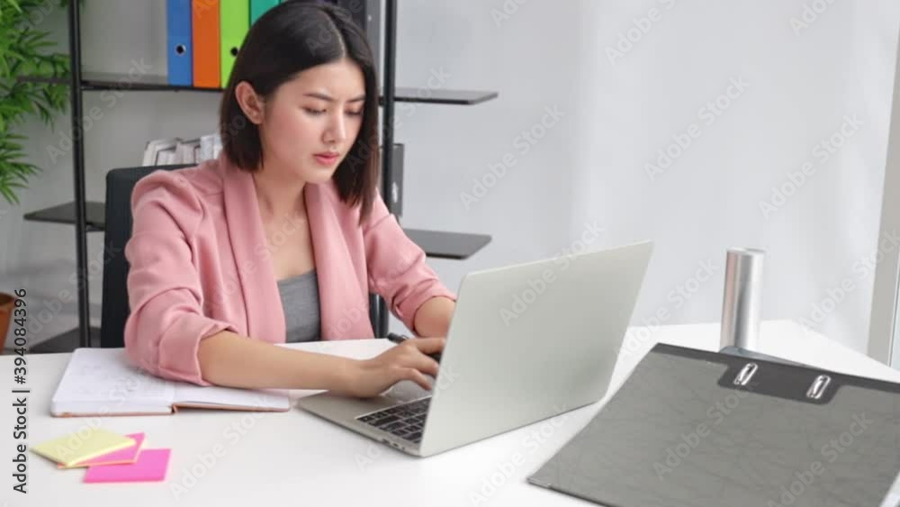Asian freelance business woman working while working on laptop in living room at office . girl sitting on desk work overtime, enjoy relax time.female working stress and problem . Asian freelance business woman working while working on laptop in living room at office . girl sitting on desk work overtime, enjoy relax time.female working stress and problem .