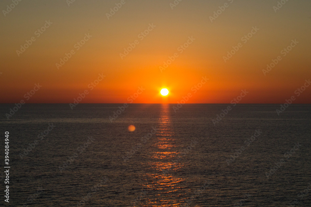 evocative image of sunrise over the sea with the sun rising on the horizon