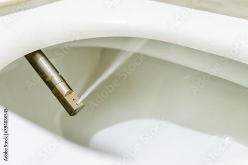Domestic toilet seat with water jet spray close up. Bathroom technologies and invetions.