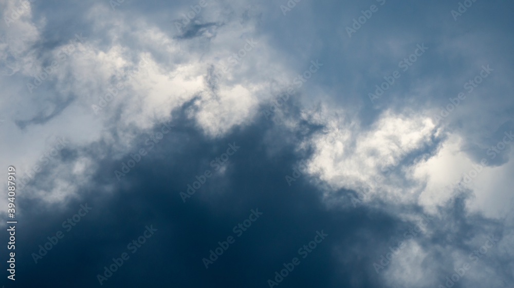 Portrait of greyscale clouds on the white sky, great as background texture.