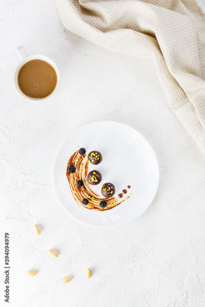 Homemade chocolates in a plate with a cup of coffee. Sugar, gluten and lactose free. Homemade chocolates in a plate with a cup of coffee. Sugar, gluten and lactose free.