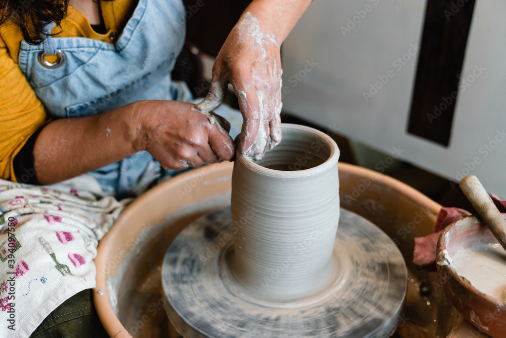 Potter making ceramic pot on the pottery wheel with hands Potter making ceramic pot on the pottery wheel with hands