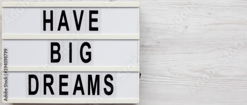 'Have Big Dreams' on a lightbox on a white wooden background, top view. Flat lay, overhead, from above. Space for text.