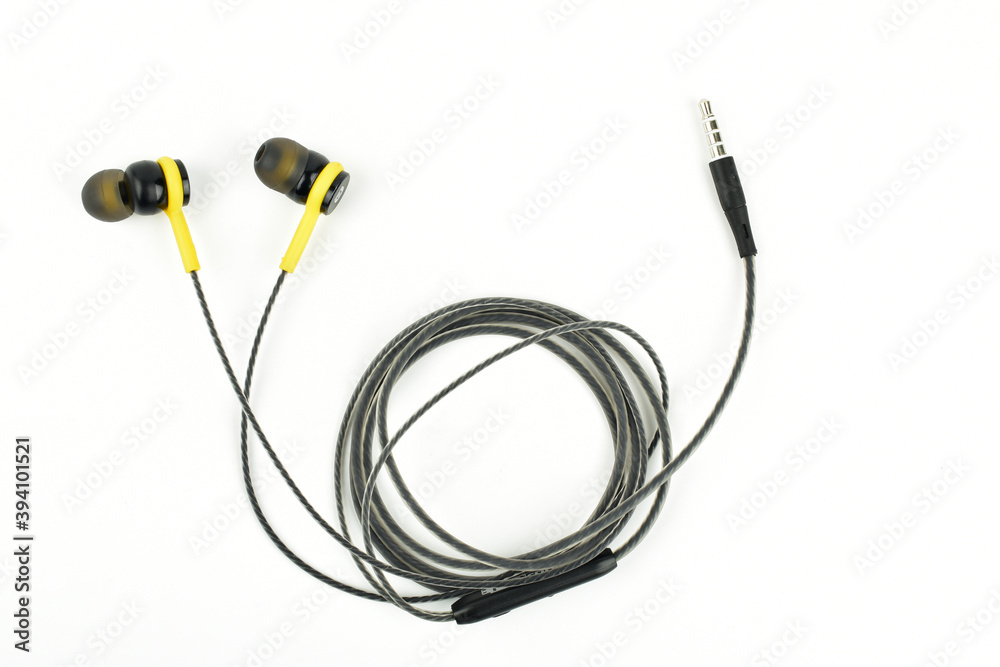 Black and yellow color earphone on white background, top view
