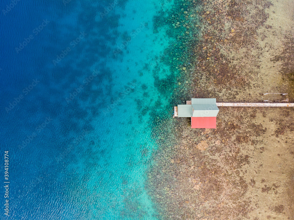 Fototapeta premium Aerial drone view of polynesian small Caribbean island with bungalows in Barrier Reef