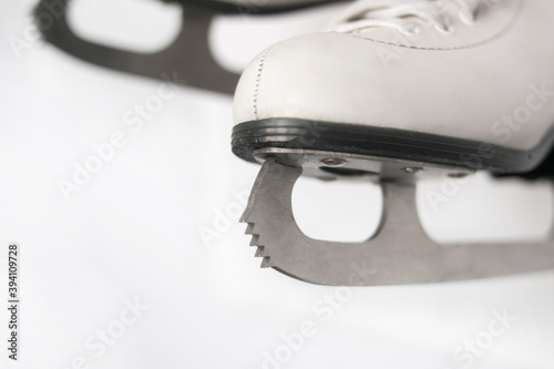 White figure skates with silver blades and prong close-up on a white background