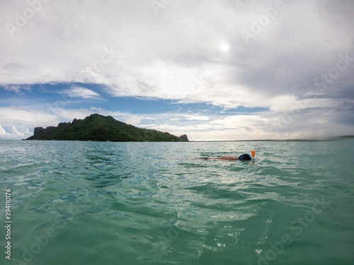 person snorkeling tropical island in french polynesia 