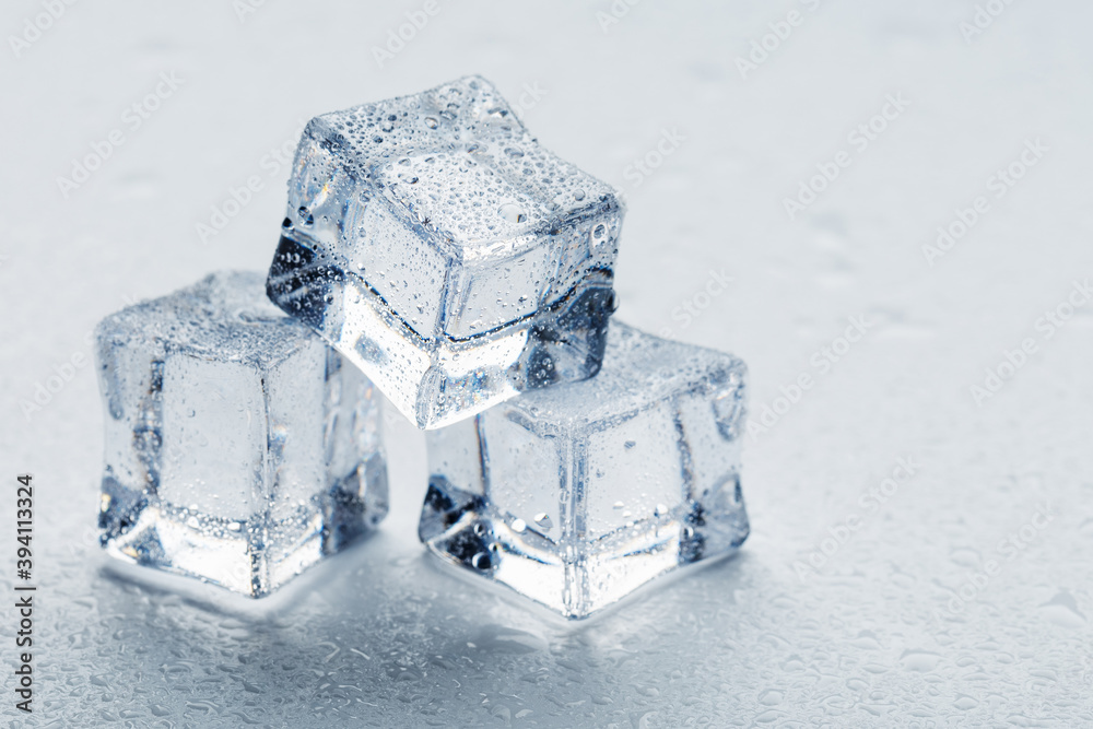 Ice with meltwater drops close-up on a white background. Ice with meltwater drops close-up on a white background.