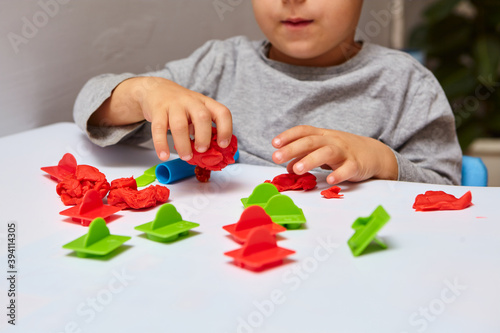 The boy is playing in his room. Young child playing with play doh or play dough. Educational toys for kid's. Games for Child Development.Child's hands kneading modelling clay. photo