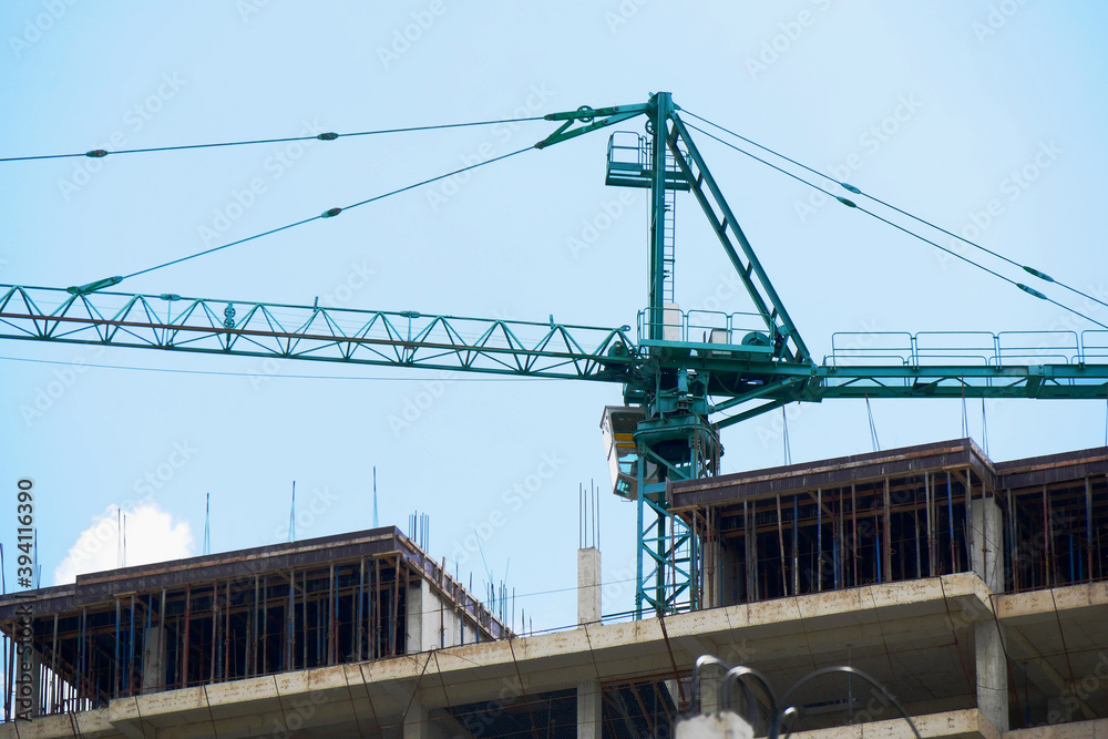 Сrane near building. Concrete building under construction.