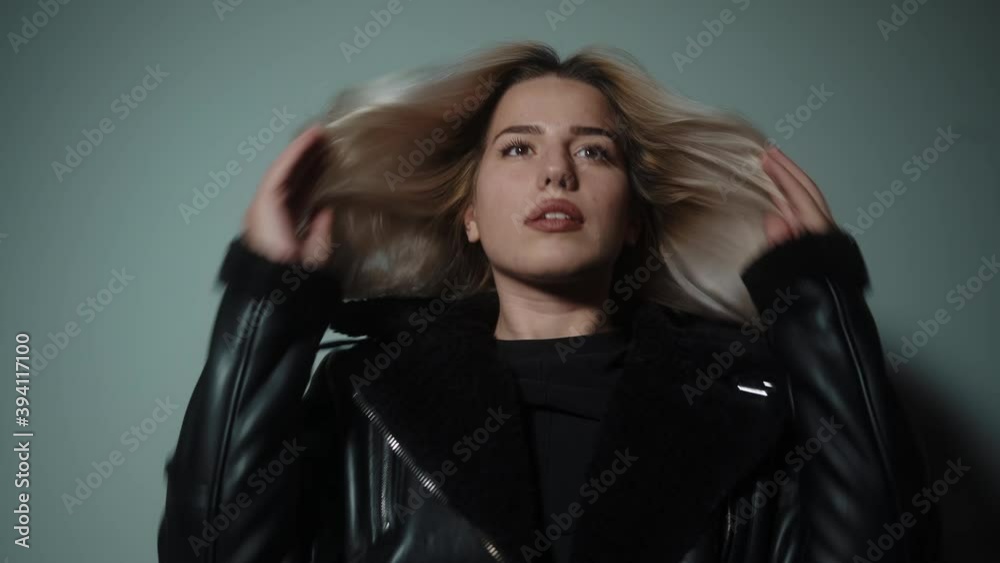 Alluring young sexy and beautiful blonde woman looking at camera giving attractive poses in cyan-color studio background, lifestyle, fashion and photography concept Alluring young sexy and beautiful blonde woman looking at camera giving attractive poses in cyan-color studio background, lifestyle, fashion and photography concept