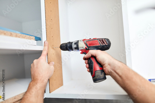 Wallpaper Mural Handyman worker assembling furniture in new apartment, moving in and being hardworking. Torontodigital.ca