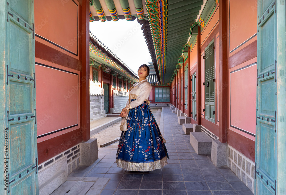 Woman wearing traditional Korean dress in front of Gyeongbokgung gate. Woman wearing traditional Korean dress in front of Gyeongbokgung gate.