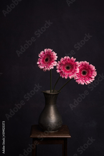 Wallpaper Mural Painterly still life of three pink Gerbera flowers in antique vase on stool  Torontodigital.ca