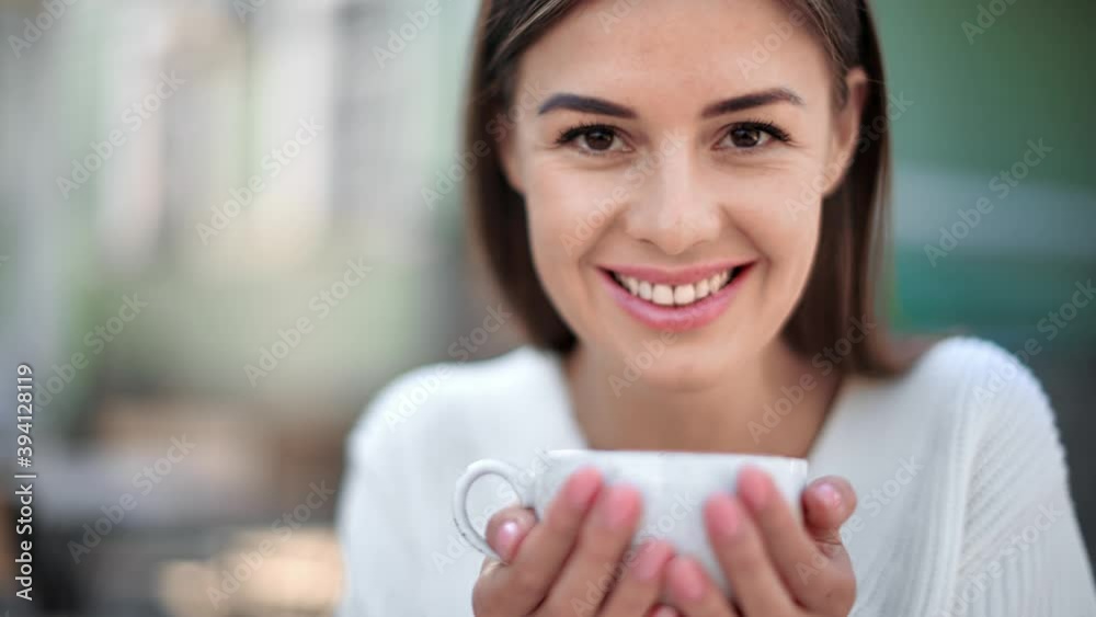 Closeup happy woman holding cup with hot beverage warming hands outdoor. 4k Dragon RED camera Closeup happy woman holding cup with hot beverage warming hands outdoor. 4k Dragon RED camera