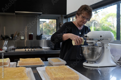 Senior lady making cakes for fundraising event photo