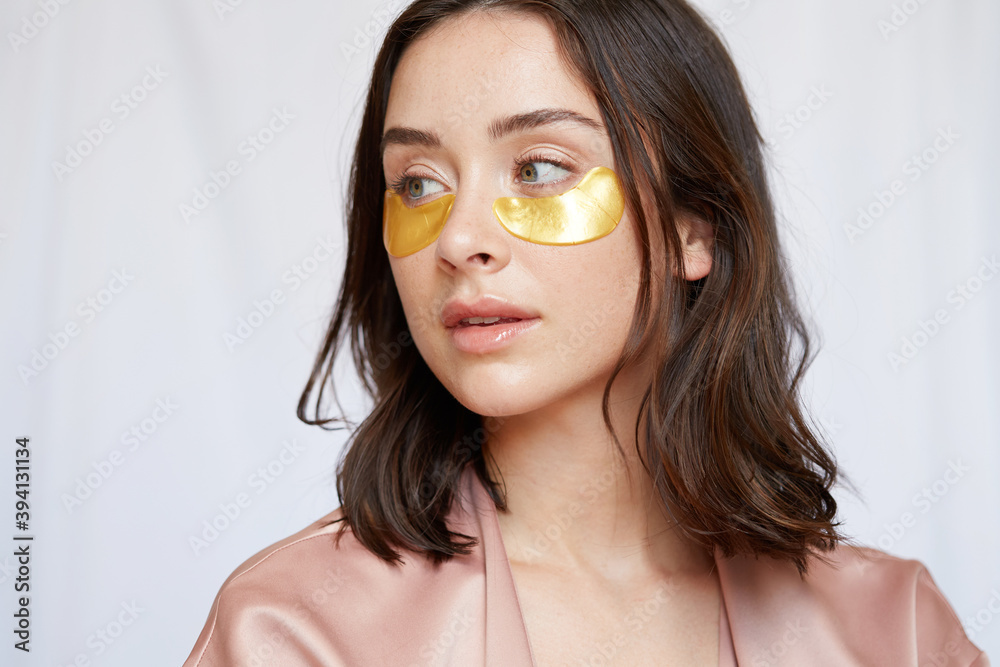 Woman using gold eye patches Woman using gold eye patches