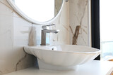 Close up shot of polished chrome one handle faucet and shell shaped wash basin in the kitchen. Copy space, background.