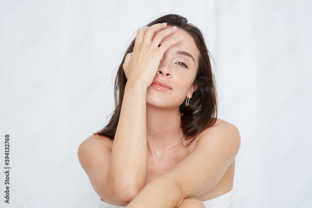 Playful shot of young woman covering one eye Playful shot of young woman covering one eye