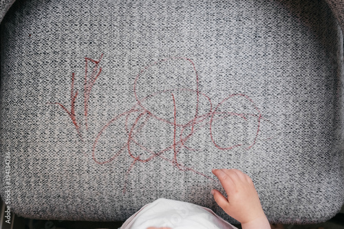 Anonymous toddler coloured on an armchair photo